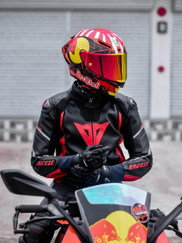 A Person in Black and Red Motorcycle Suit Riding on a Motorcycle